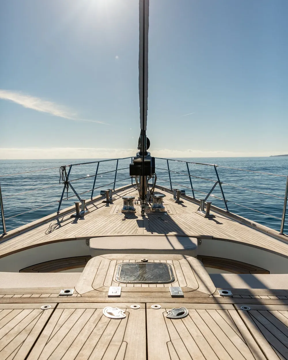 A view forward along the teak deck past the rigging to the open sea