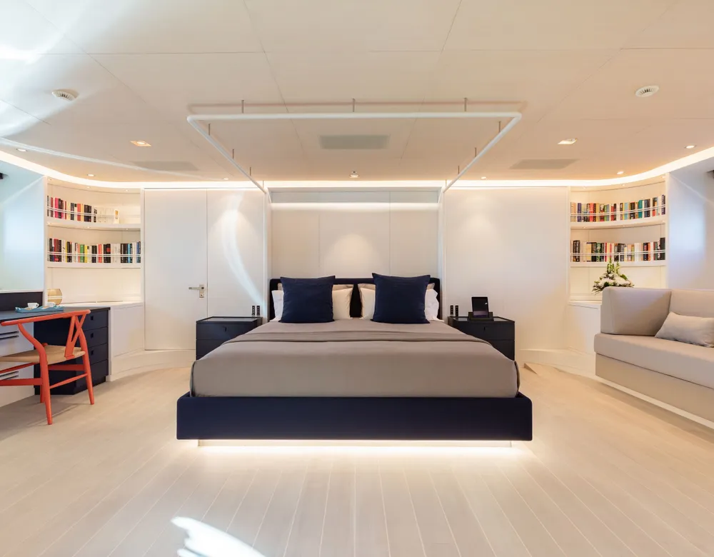 The full-beam owner’s cabin with a queen-size bed, pale upholstery and soft lighting