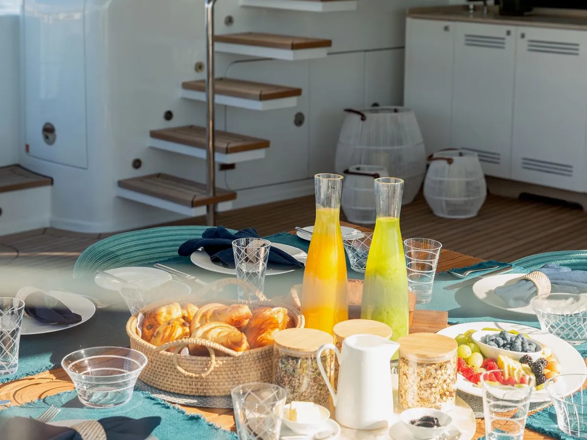 A breakfast spread on the aft deck with the flybridge staircase and galley behind