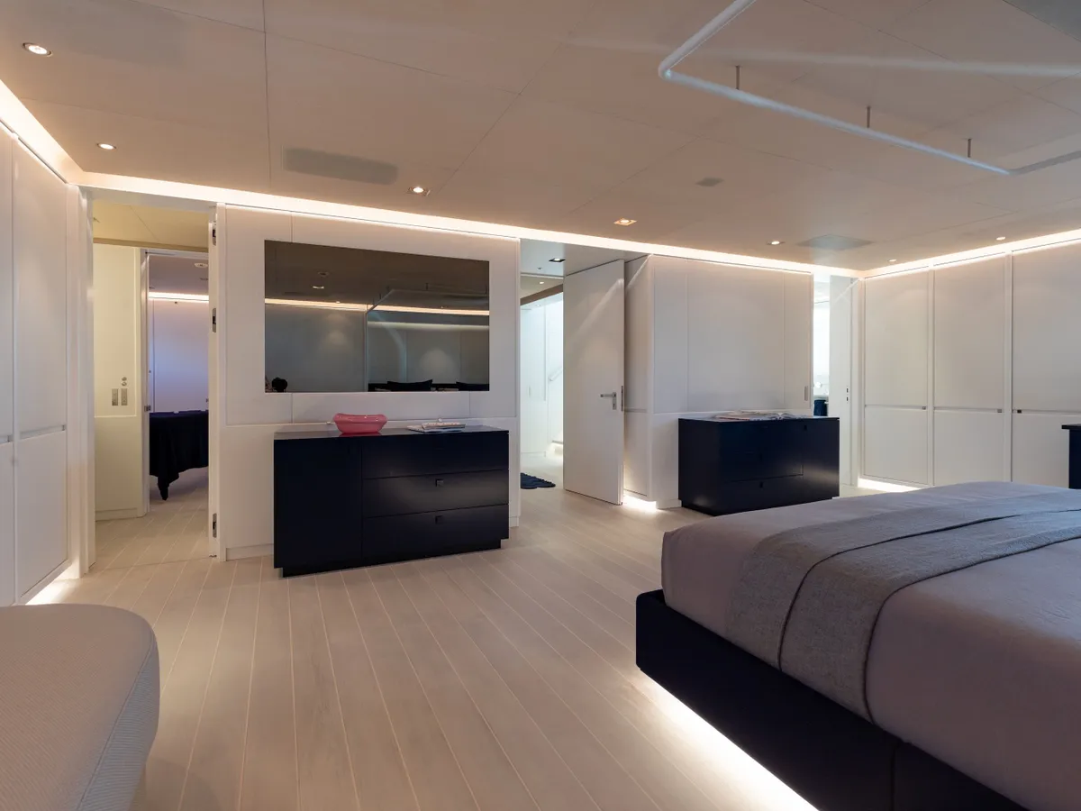 A guest cabin with dark cabinetry and doors open to the ensuite beyond
