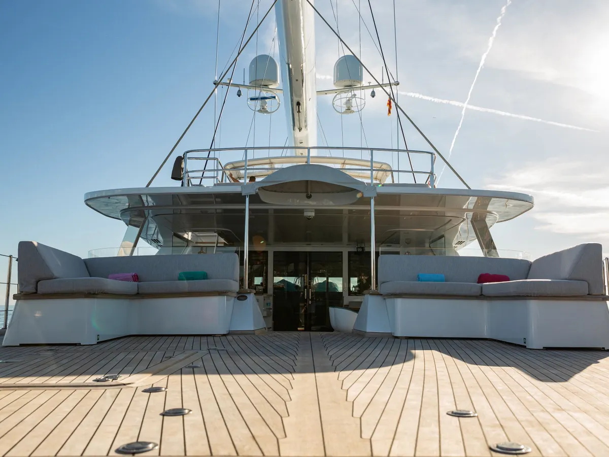 Twin lounge sofas on the aft deck facing the flybridge canopy and helm