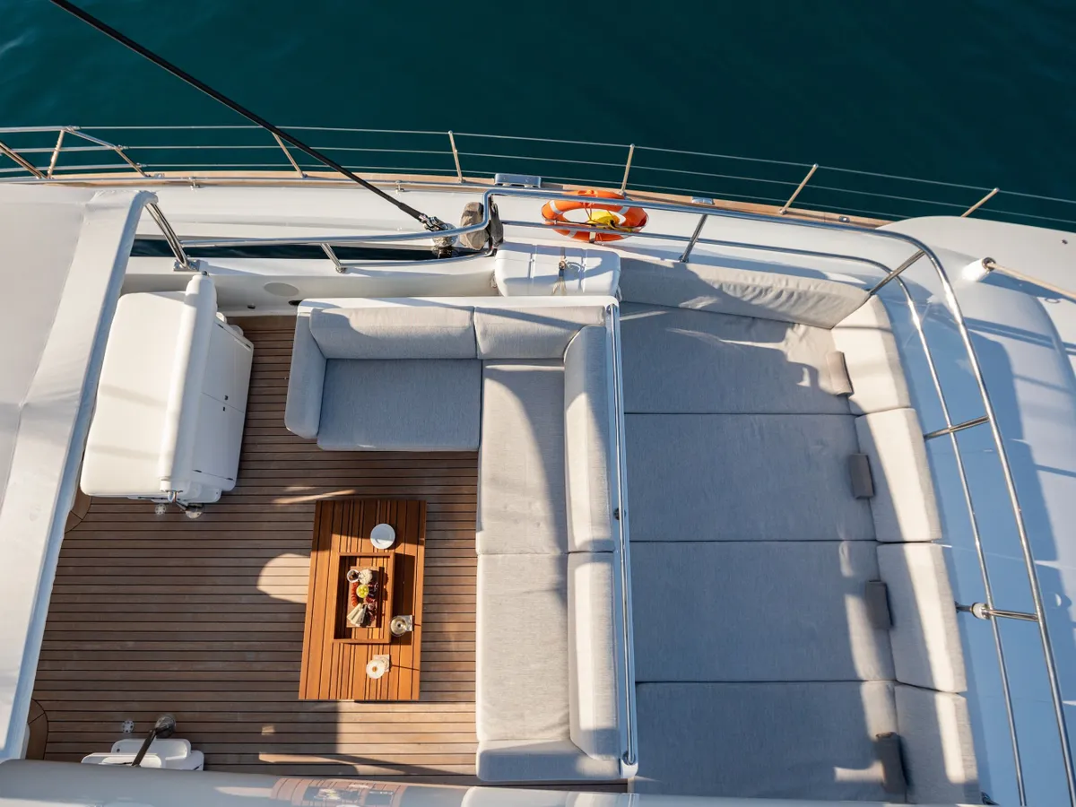 The upper deck lounge seen from above, with white sofas beside turquoise water