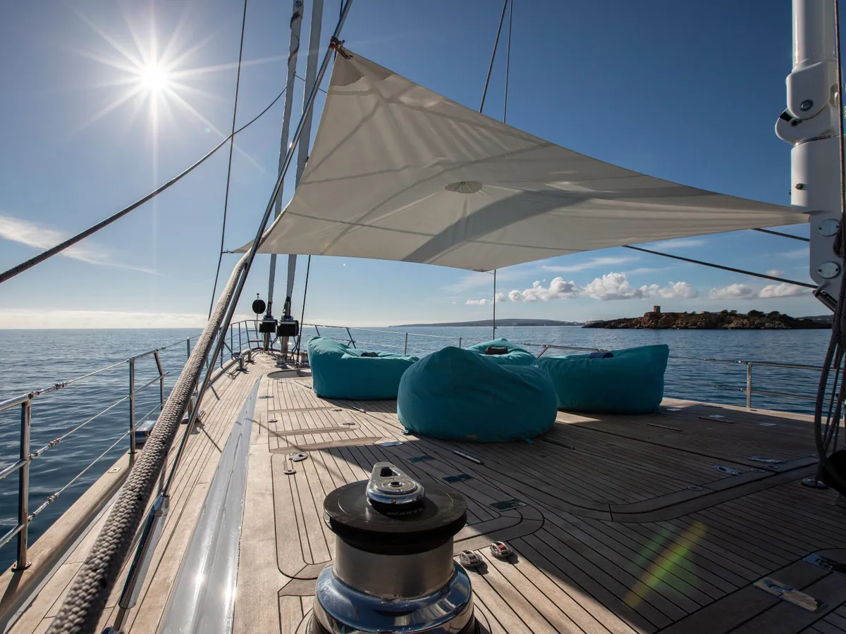 Turquoise beanbags on the foredeck beneath a white sun awning