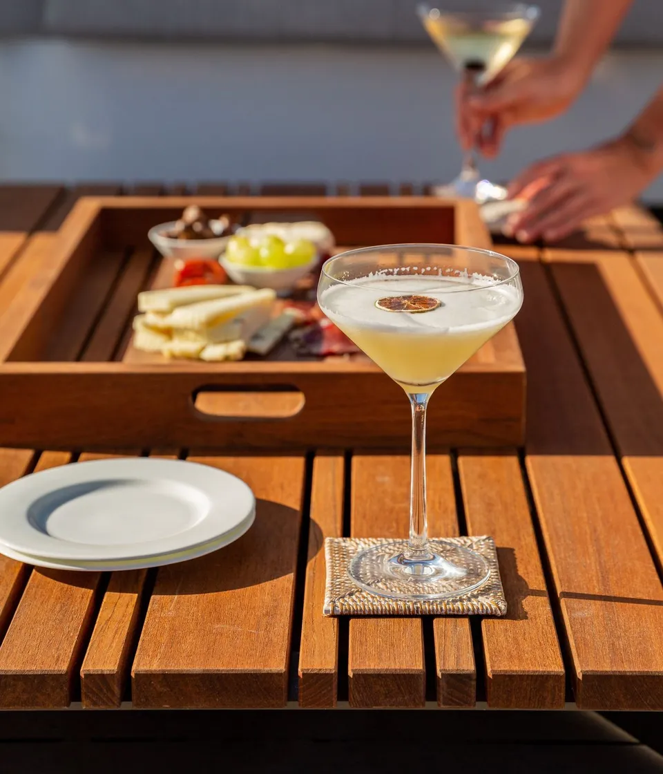 A cocktail and a selection of small bites served on deck